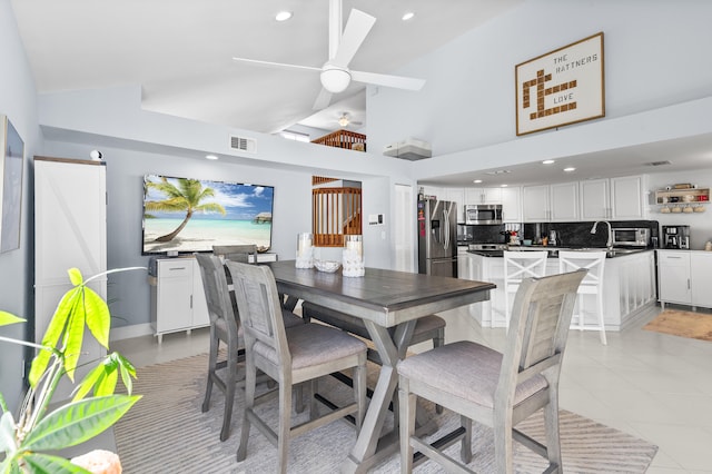 tiled dining room with ceiling fan and vaulted ceiling