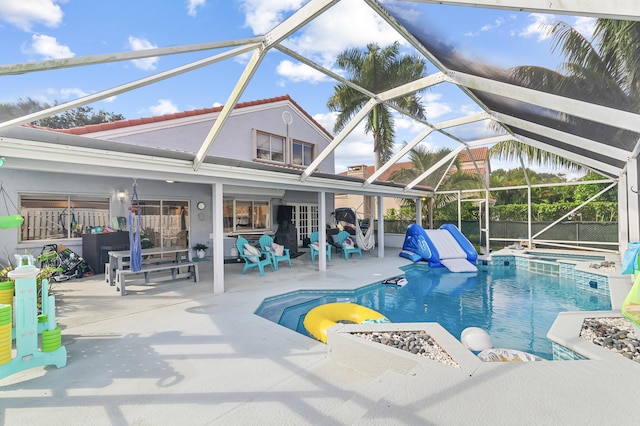 view of swimming pool featuring a patio, glass enclosure, and an outdoor fire pit