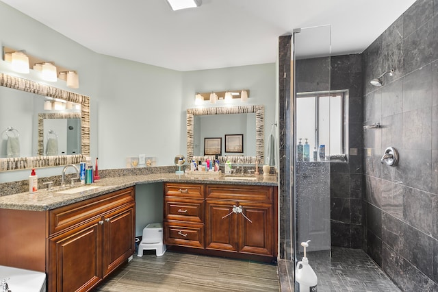 bathroom with vanity and a tile shower