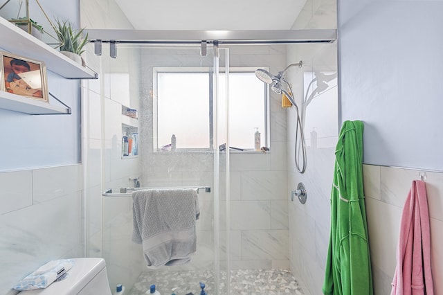 bathroom featuring toilet and a shower with shower door