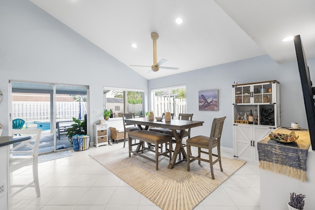 tiled dining space featuring ceiling fan and high vaulted ceiling