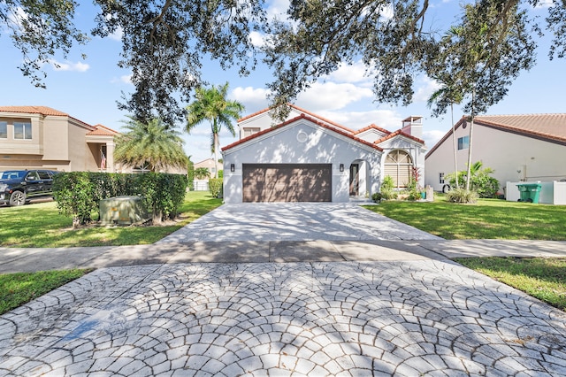 mediterranean / spanish-style home featuring a garage and a front lawn