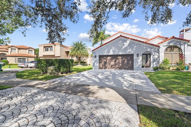 mediterranean / spanish-style house with a garage and a front lawn