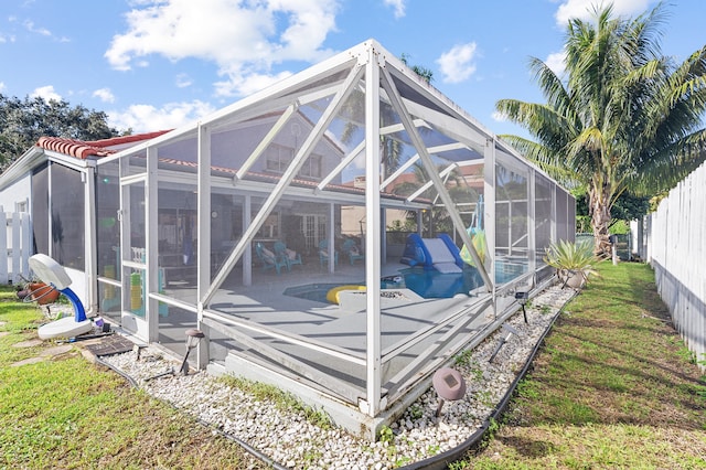 back of house with a lanai, a fenced in pool, a patio area, and a yard