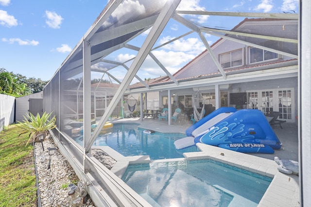 view of pool featuring glass enclosure and a patio