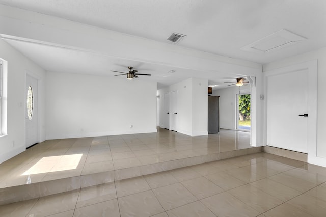 tiled spare room with ceiling fan