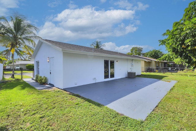 rear view of house featuring central AC unit, a patio area, and a yard