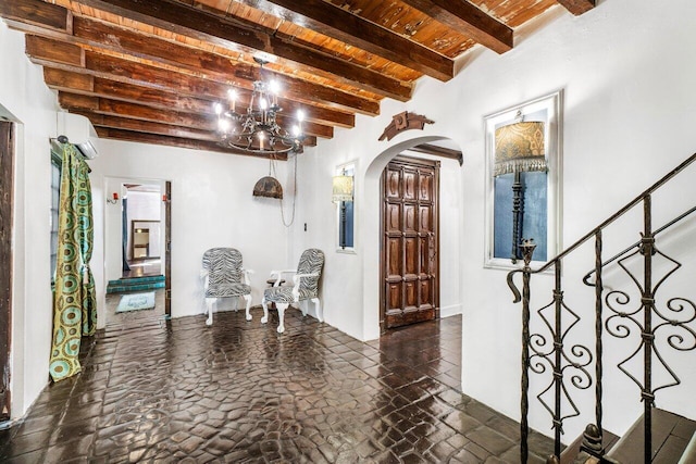 entrance foyer with arched walkways, beam ceiling, and wood ceiling