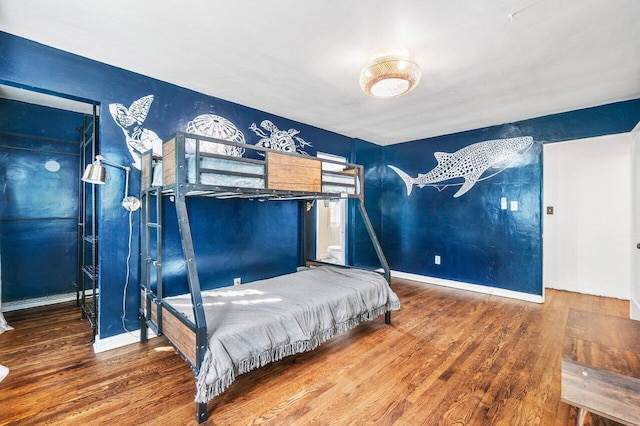 bedroom featuring baseboards and wood finished floors