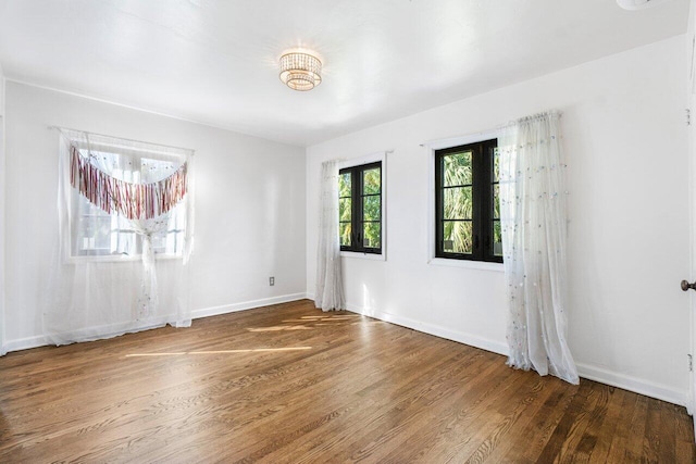 empty room with baseboards and wood finished floors