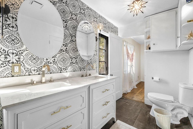 full bathroom featuring a sink, visible vents, toilet, and double vanity