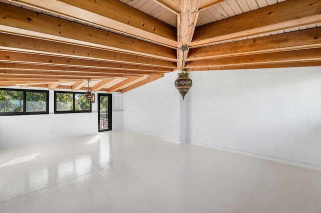 interior space featuring beamed ceiling, concrete flooring, and baseboards