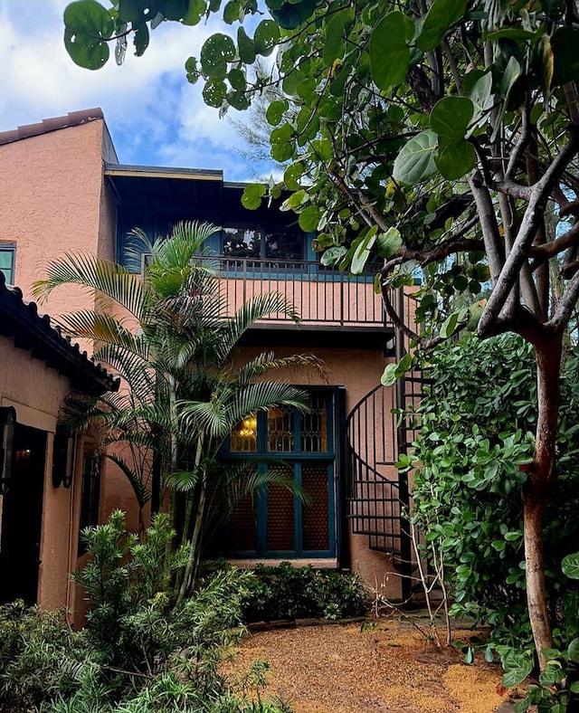 back of house featuring stairway and stucco siding