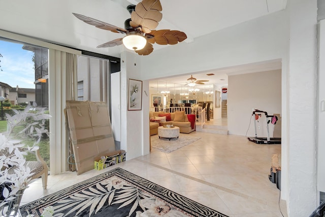 tiled foyer entrance with ceiling fan with notable chandelier