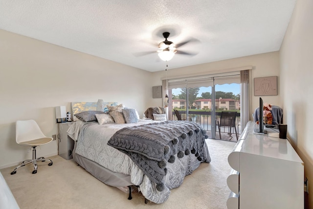 carpeted bedroom with access to outside, a textured ceiling, and ceiling fan