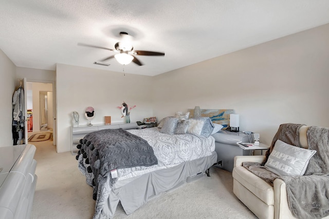 carpeted bedroom featuring a textured ceiling and ceiling fan