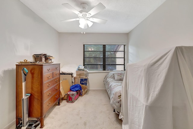 carpeted bedroom with ceiling fan and a textured ceiling