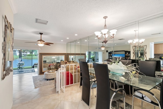 tiled dining room with crown molding, a textured ceiling, a water view, and ceiling fan with notable chandelier