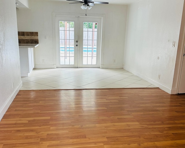 spare room with ceiling fan, light wood-type flooring, and french doors