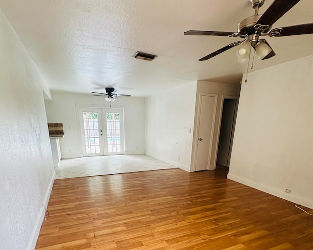 spare room with french doors, light wood-type flooring, and ceiling fan