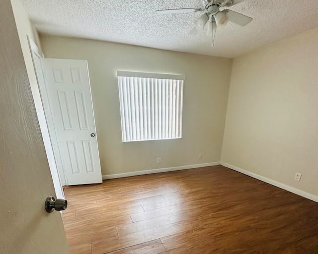 spare room with ceiling fan, light wood-type flooring, and a textured ceiling