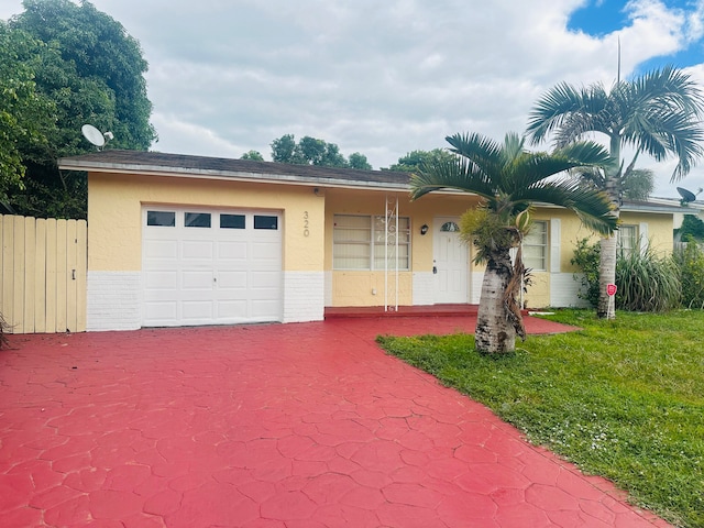 single story home featuring a garage and a front yard