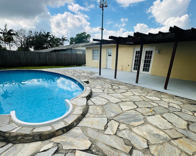 view of swimming pool featuring french doors and a patio area