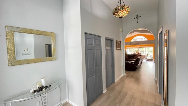 corridor featuring high vaulted ceiling and light wood-type flooring