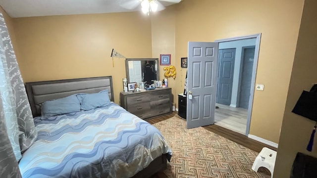 bedroom with ceiling fan, light wood-type flooring, and lofted ceiling