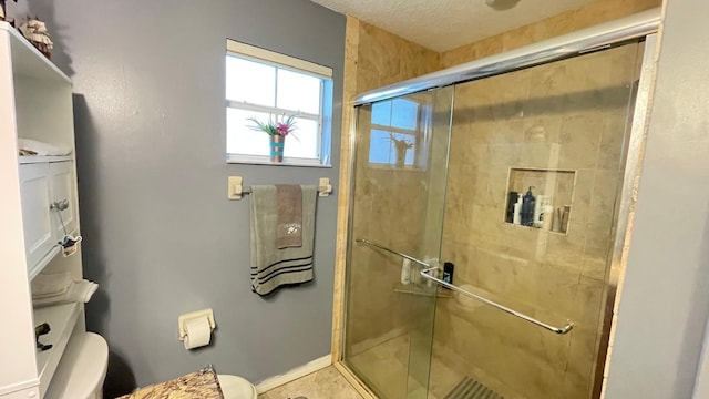 bathroom featuring an enclosed shower, a textured ceiling, and toilet