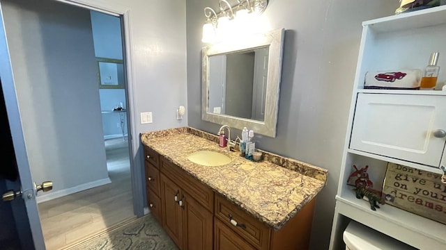 bathroom featuring toilet, vanity, and wood-type flooring