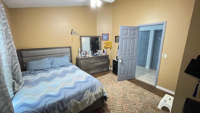 bedroom featuring light wood-type flooring and vaulted ceiling