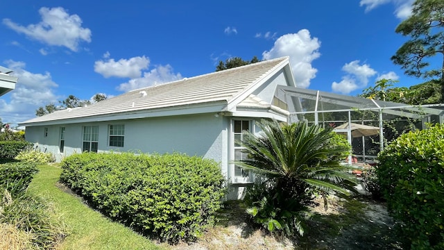 view of home's exterior with glass enclosure