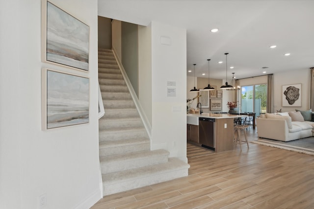 stairs with sink and hardwood / wood-style flooring