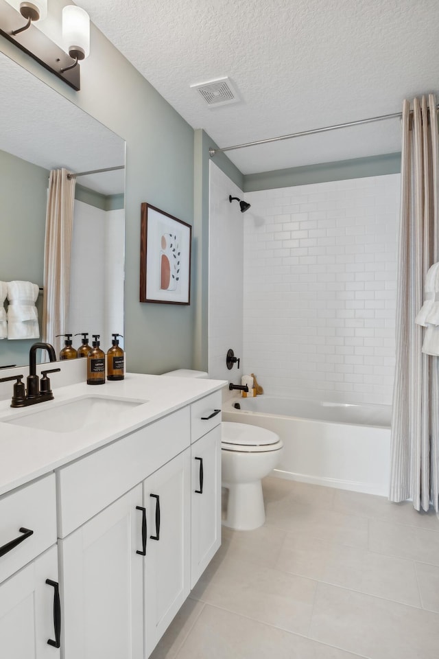 full bathroom with tile patterned floors, shower / bath combo, toilet, vanity, and a textured ceiling