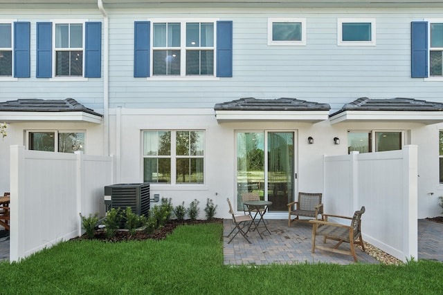 rear view of house with a patio area, a lawn, and cooling unit