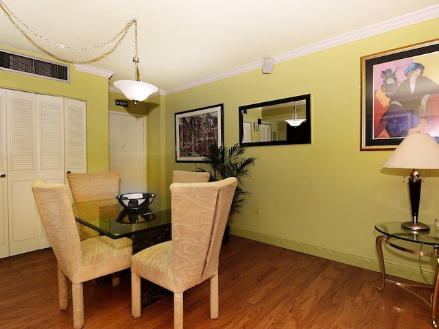 dining space with crown molding and hardwood / wood-style flooring