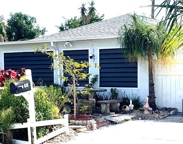 view of front of home with a garage and roof with shingles