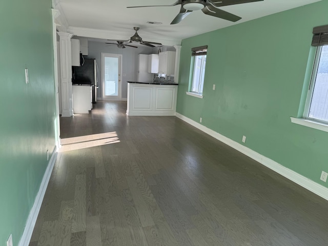 interior space with dark wood-style flooring, dark countertops, visible vents, white cabinets, and baseboards