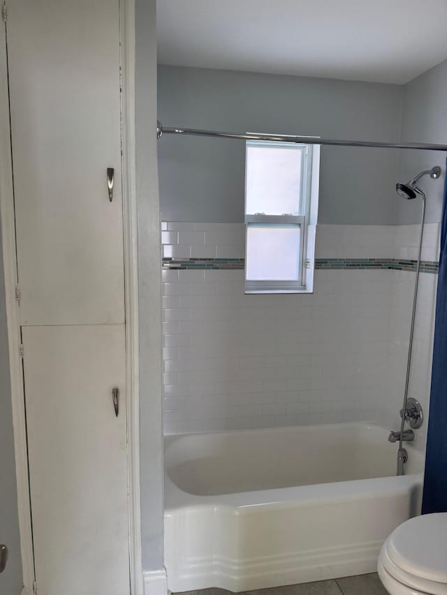 full bathroom with bathtub / shower combination, toilet, and tile patterned floors