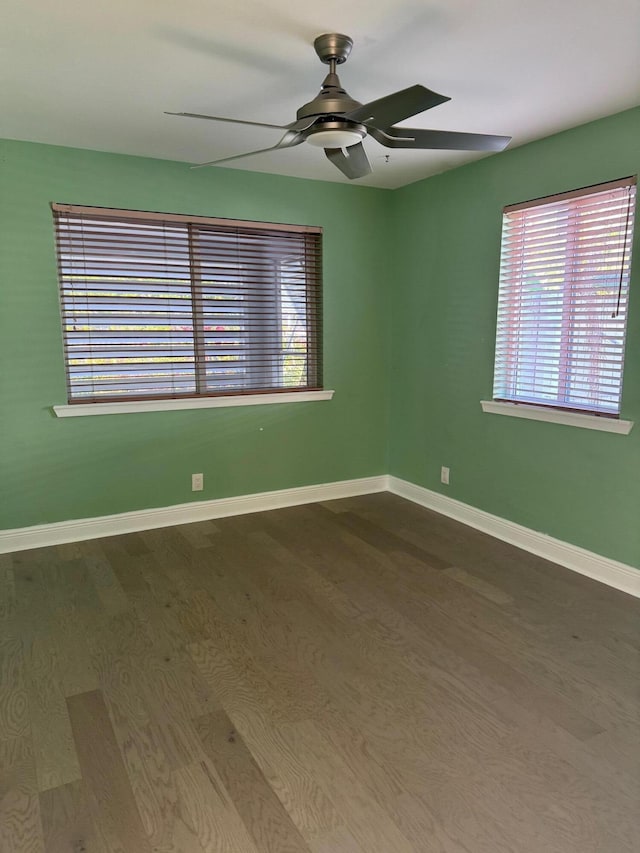 spare room featuring wood finished floors, a ceiling fan, and baseboards