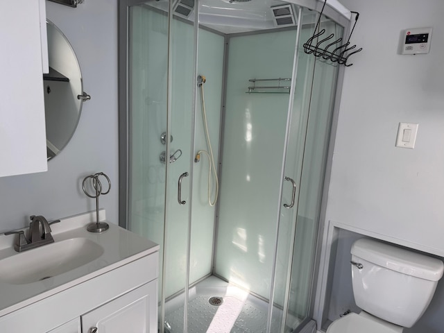 bathroom with toilet, visible vents, a stall shower, and vanity