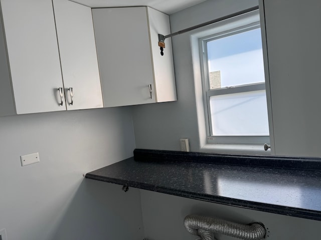 kitchen featuring dark countertops and white cabinetry