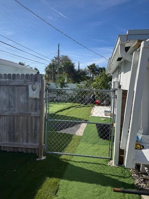 view of gate with a yard and fence