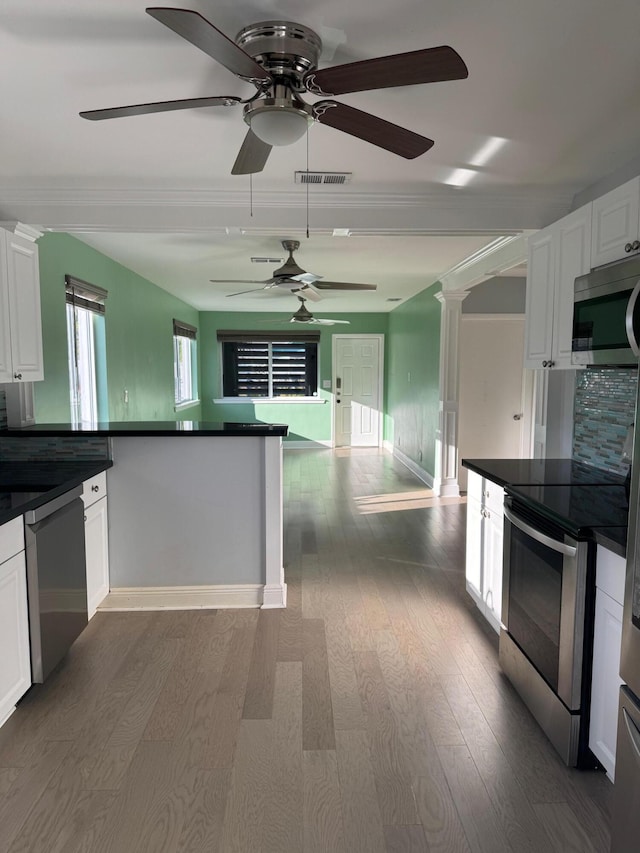 kitchen featuring appliances with stainless steel finishes, dark countertops, and white cabinetry