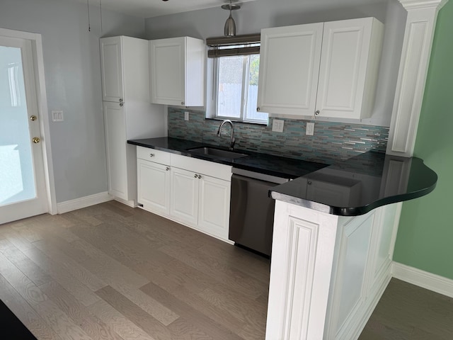 kitchen featuring dark wood-style floors, dark countertops, a sink, and white cabinetry