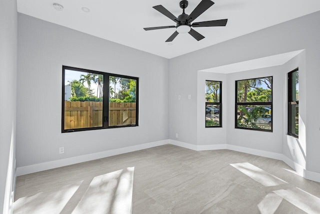 spare room featuring light carpet, a healthy amount of sunlight, and ceiling fan