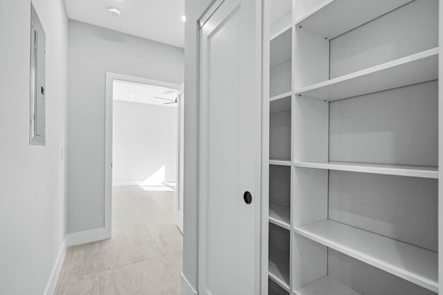 corridor with light tile patterned floors and electric panel