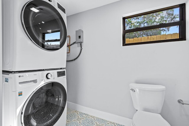 laundry room with light tile patterned floors and stacked washer and clothes dryer