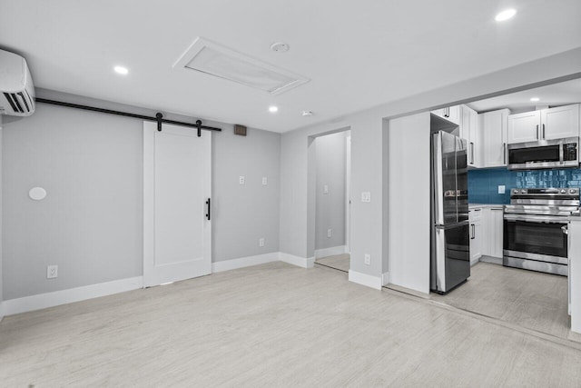 living room featuring light hardwood / wood-style floors, a barn door, and an AC wall unit